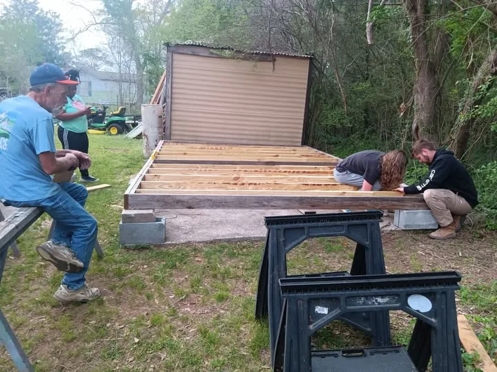 Springboards vocational trainees in hard hats collaborating on an outdoor construction build