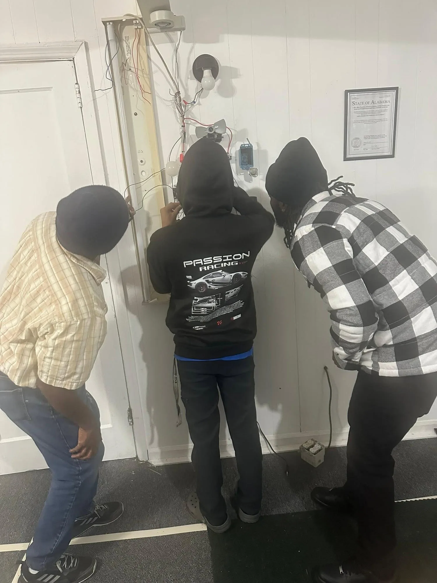 Group of construction trade students collaborating together around a workshop project station