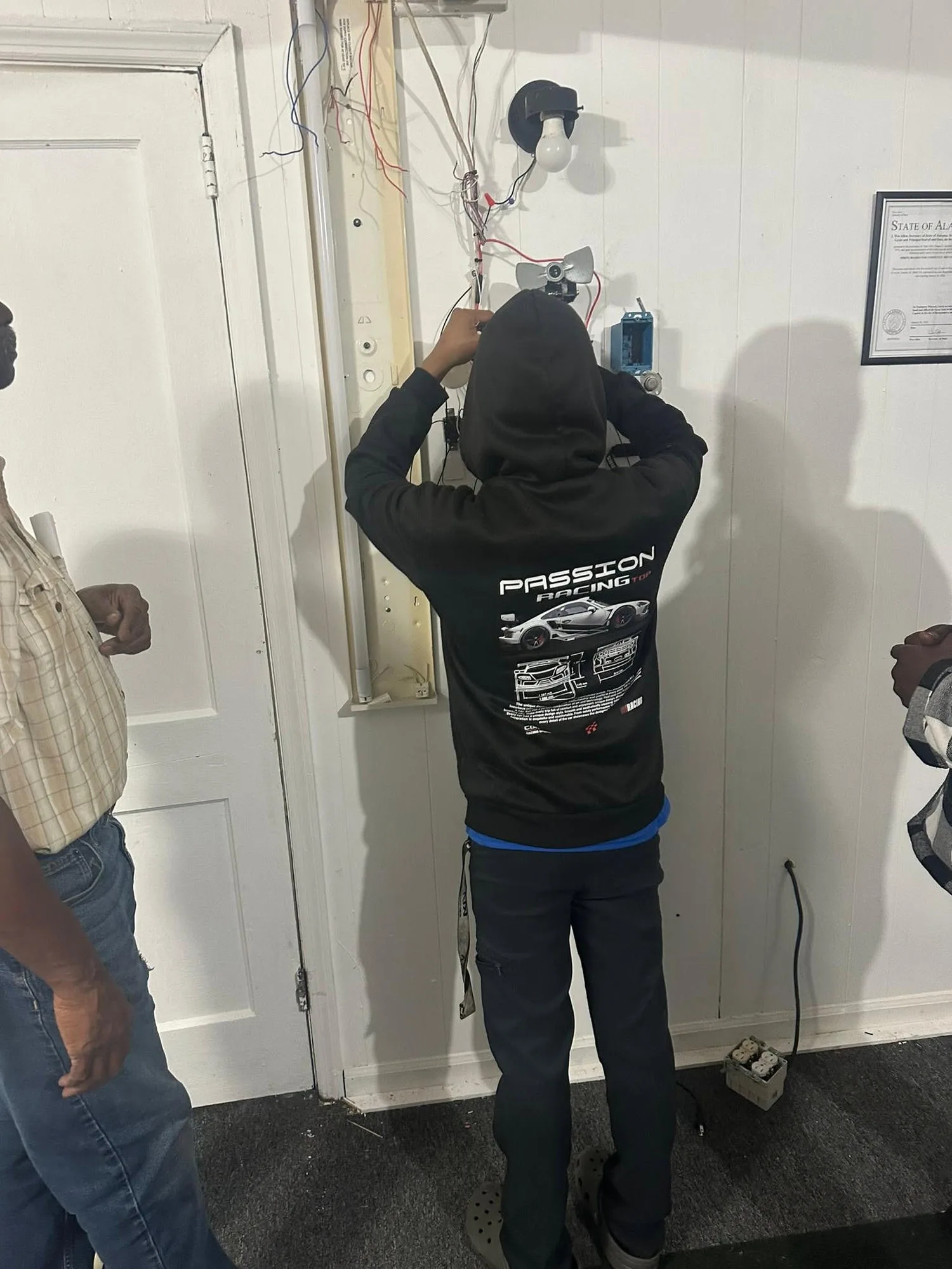 Springboards trade apprentice wearing safety goggles while carefully installing electrical conduit